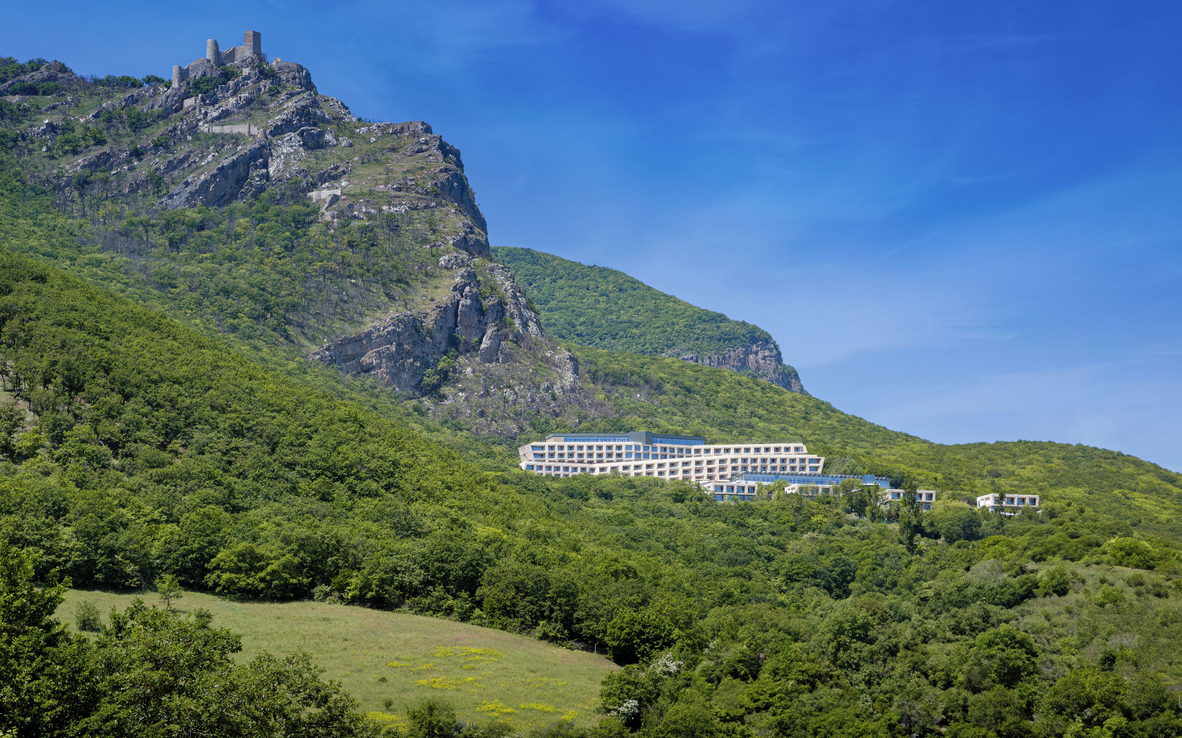 Un hotel de diseño moderno, ubicado en una ladera con vistas a la montaña.
