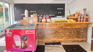 Un moderno vestíbulo de hotel con una recepción, una amplia exposición de helados y vistas al exterior.
