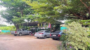Un estacionamiento con tres coches y una estructura cubierta con banderas.