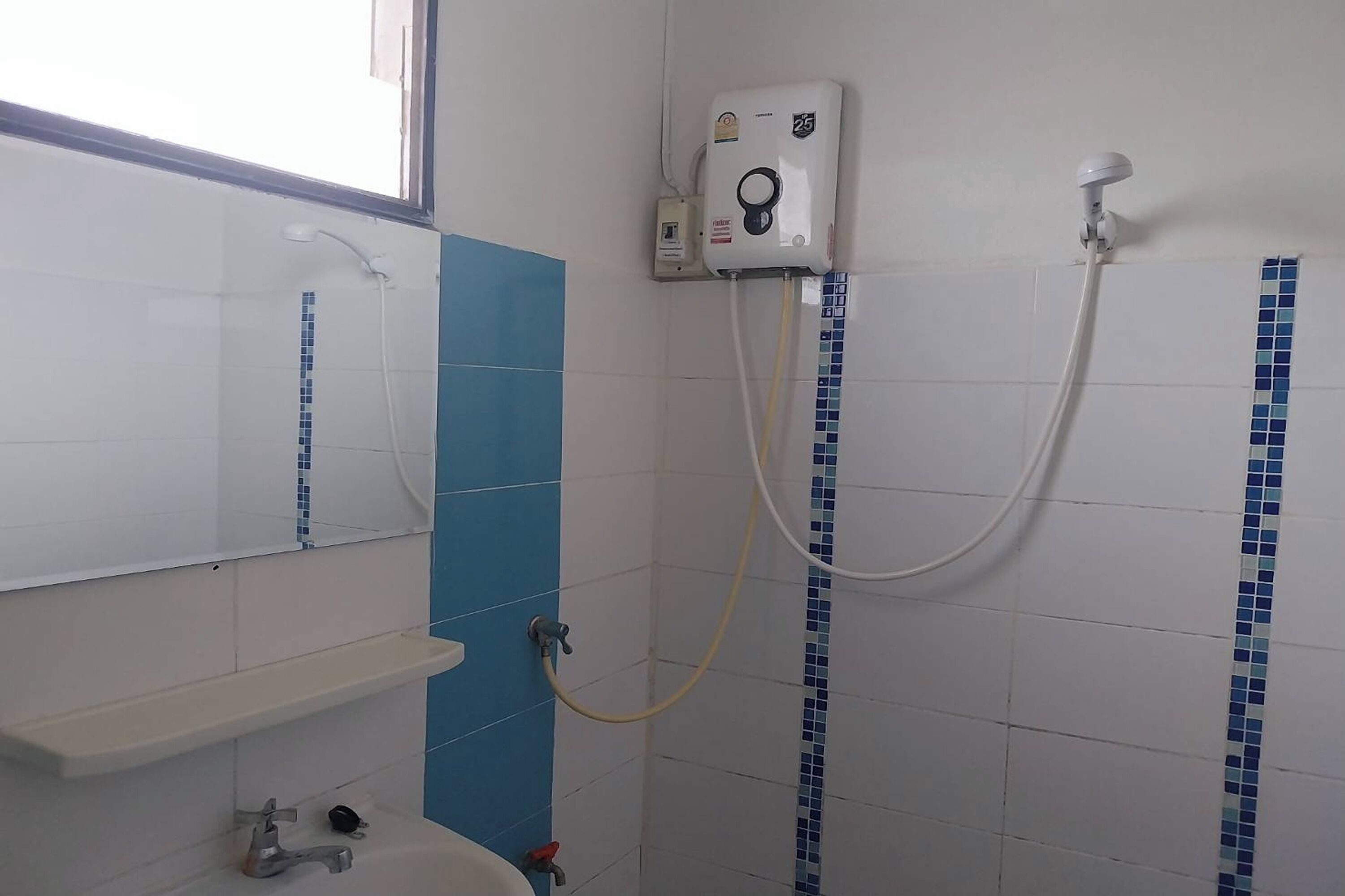 Une salle de bain avec une douche, un lavabo et un miroir.