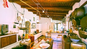 A rustic kitchen with wooden beams, hanging lights, and various kitchen utensils. - Villa Acquavella (Casal Velino)