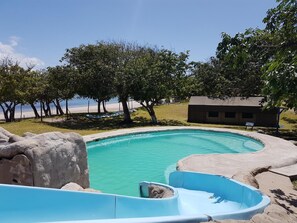 Alberca al aire libre, sombrillas en la alberca y camastros 