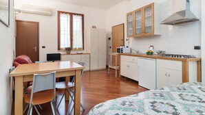 Una cocina compacta con armarios de madera, microondas, pileta y estufa.