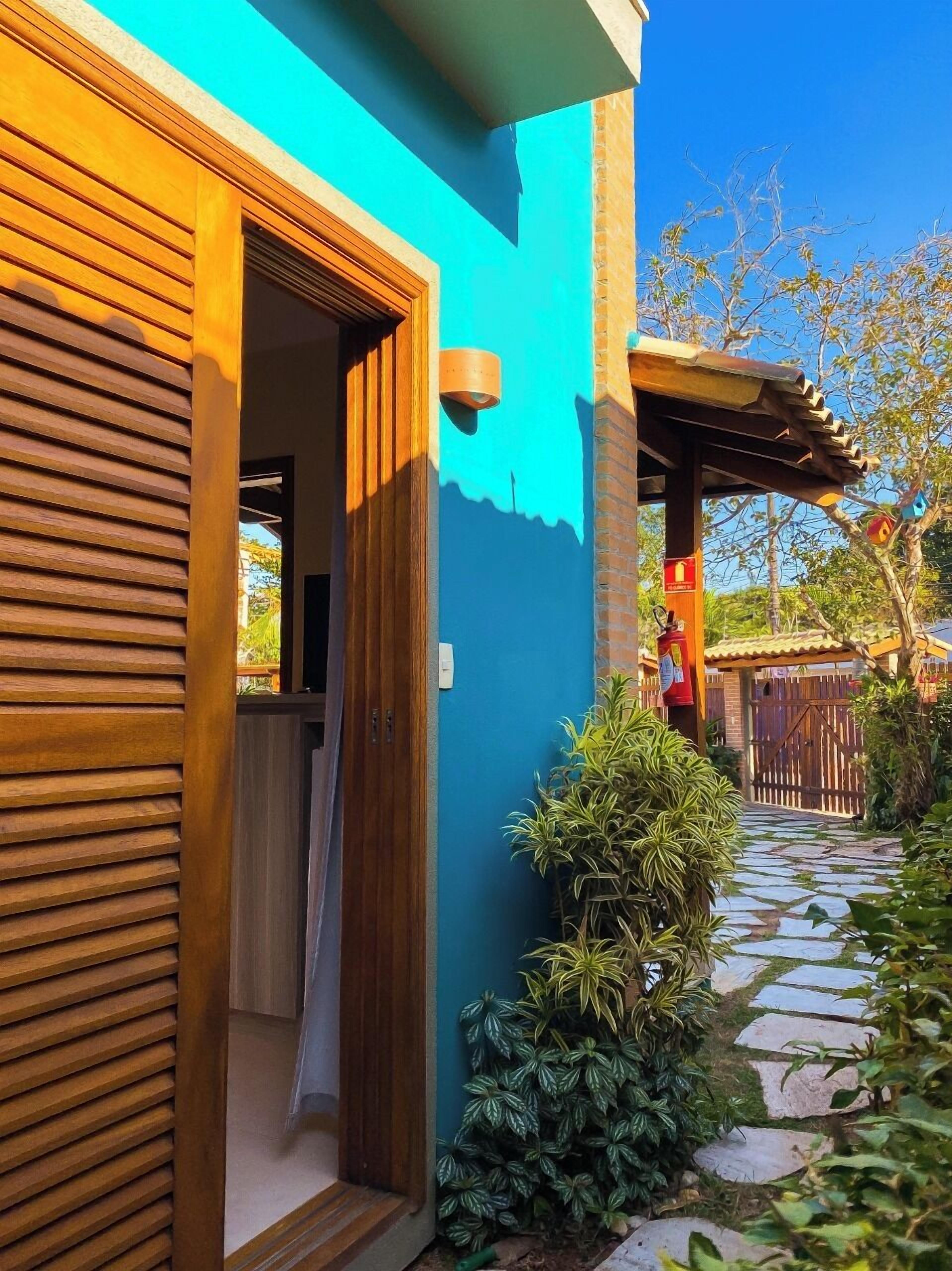 Una casa con puerta de madera y pared exterior azul.