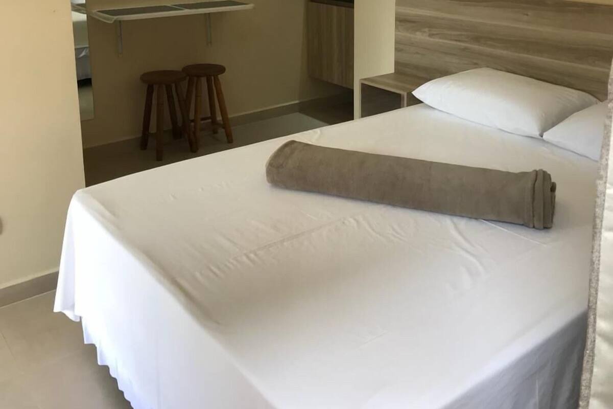 Ein Hotelzimmer mit Bett, Schreibtisch, Stuhl und einer Küchenzeile.