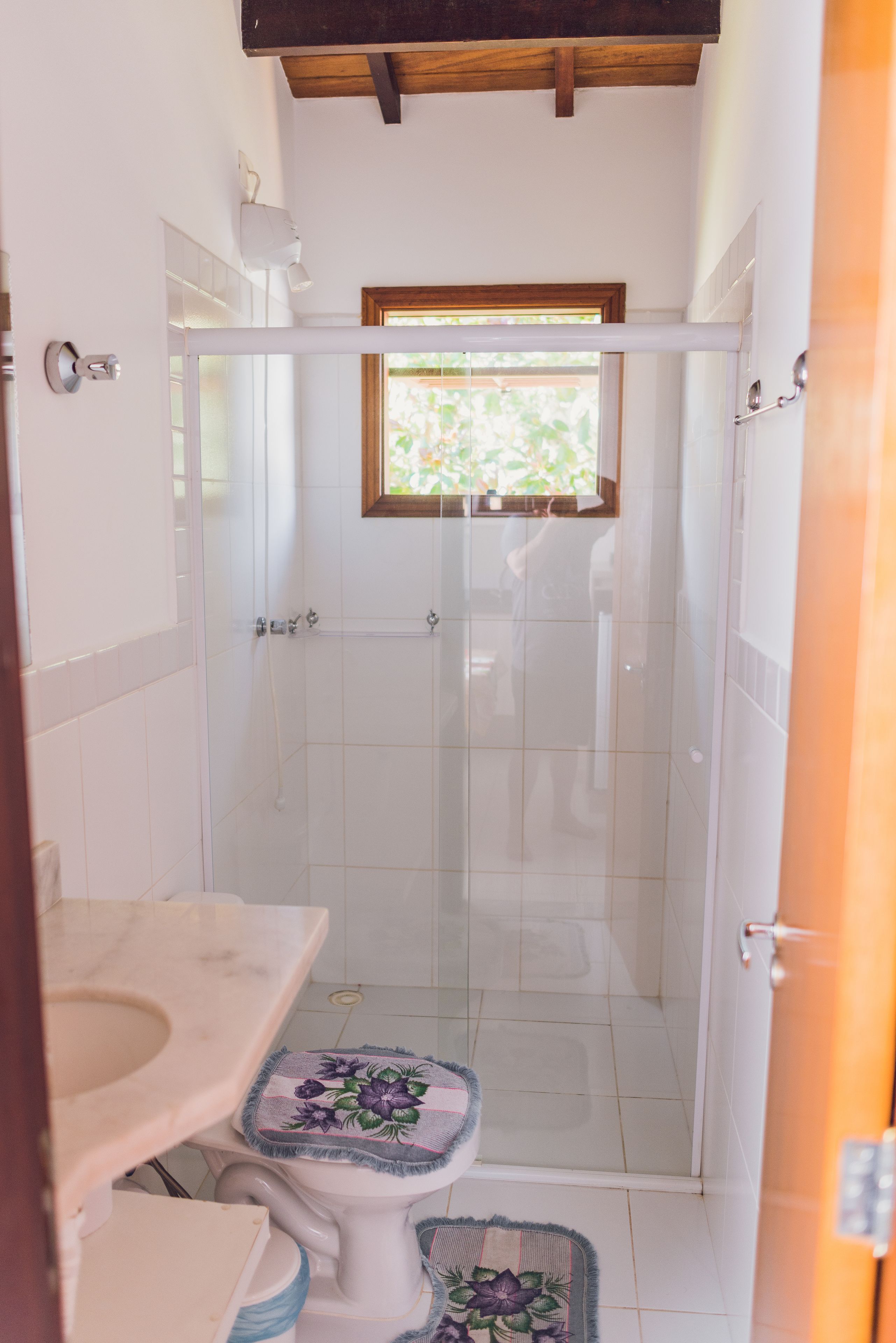 A bathroom with a toilet, sink, and shower area.