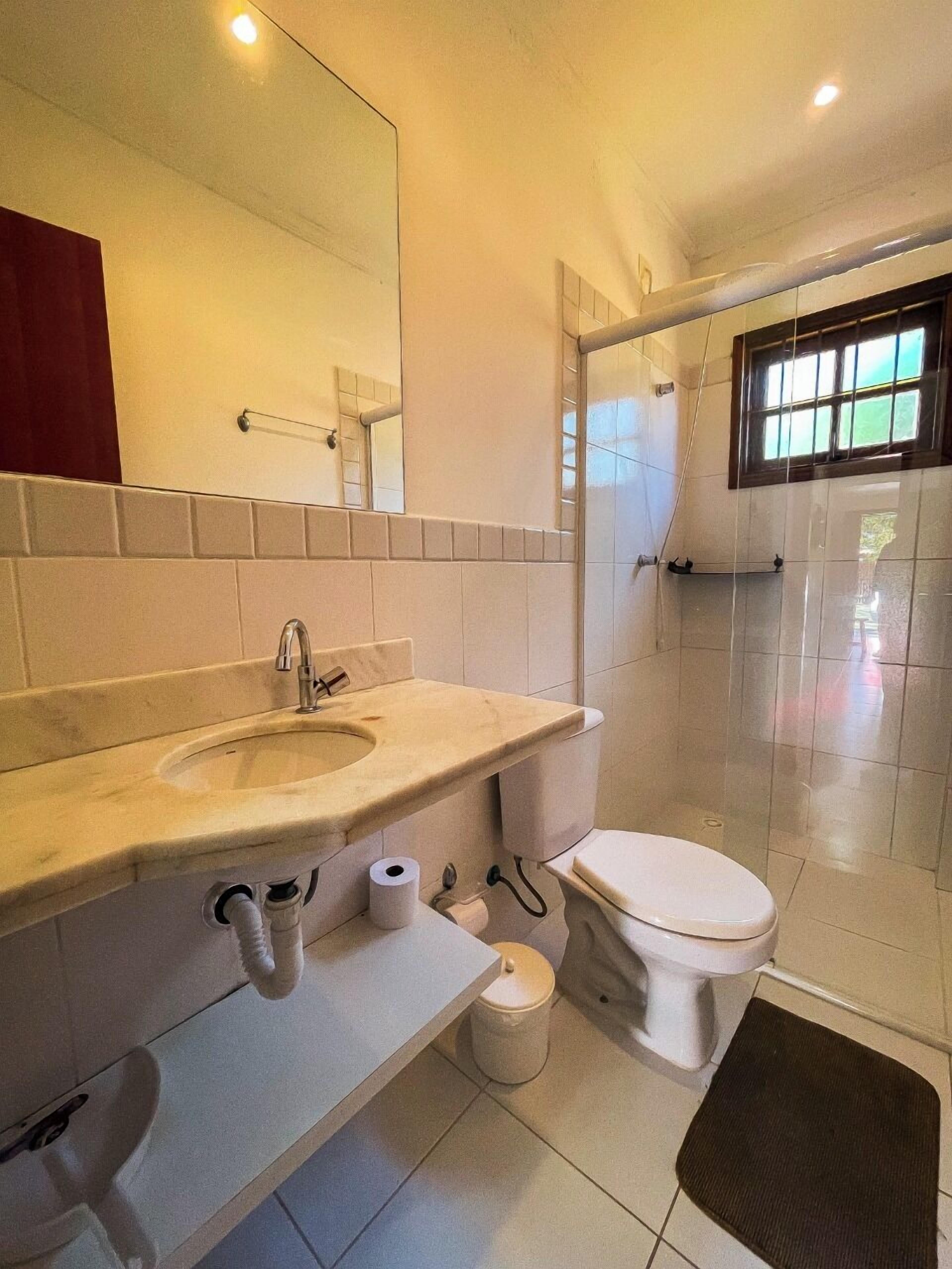 A modern bathroom with a sink, toilet, and shower.