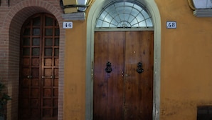 A double wooden door with a glass window above it, marked with the numbers 46 and 48. - Castiglione Lovely Mansarda (Bologna)
