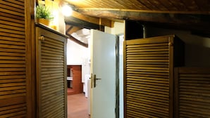 A wooden door with a latch, leading to a room with a white door and a tiled floor. - Castiglione Lovely Mansarda (Bologna)