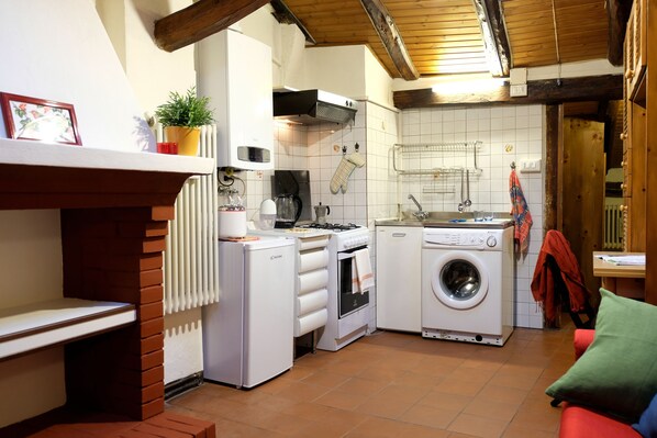 A compact kitchen with a stove, oven, microwave, and washing machine.