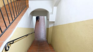 A narrow stairway with a metal handrail, leading to an arched doorway at the top. - Castiglione Lovely Mansarda (Bologna)