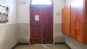 A room with a wooden double door, a small window, and a wall-mounted air conditioning unit. - Marconi Airport Cozy Dream Flat (Bologna)