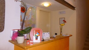 A reception desk with a map, a vase with flowers, and a sign for 'Caunolleggio'. - Costapicca B&B (Alcamo)