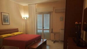 A hotel room with a bed, bedside table, chair, and a desk. - Costapicca B&B (Alcamo)