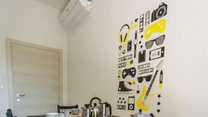 A dining area with a long table, chairs, and a wall with various icons. - Bologna Butterfly Apartment (Bologna)