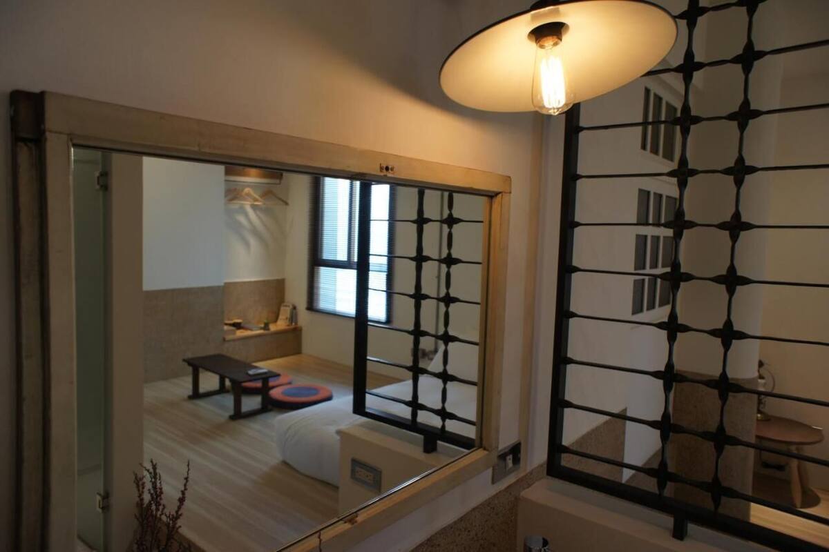 Una habitación tradicional japonesa con suelo de tatami, una mesa baja y una puerta corredera.