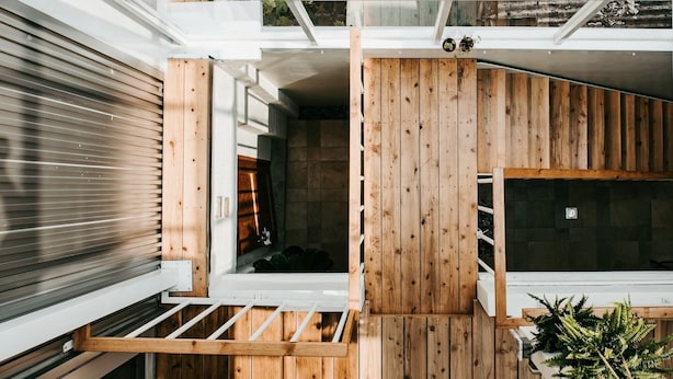 Ein modernes Interieur mit einer Wand aus Holzlatten, einer eingebauten Sitzbank und einem kleinen Fenster.
