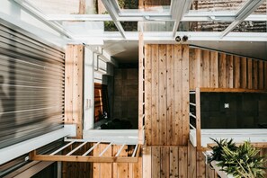 Un intérieur moderne avec un mur à lattes de bois, un banc intégré et une petite fenêtre.