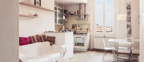 A modern apartment with a living area, kitchen, and dining space.