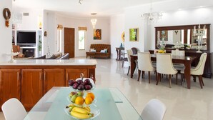 Un'ampia zona giorno con un tavolo da pranzo imbandito per sei persone, una cucina con mobili in legno e un grande specchio sopra il tavolo da pranzo.