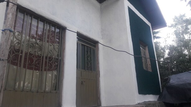 Un edificio con dos puertas y ventanas con barrotes.