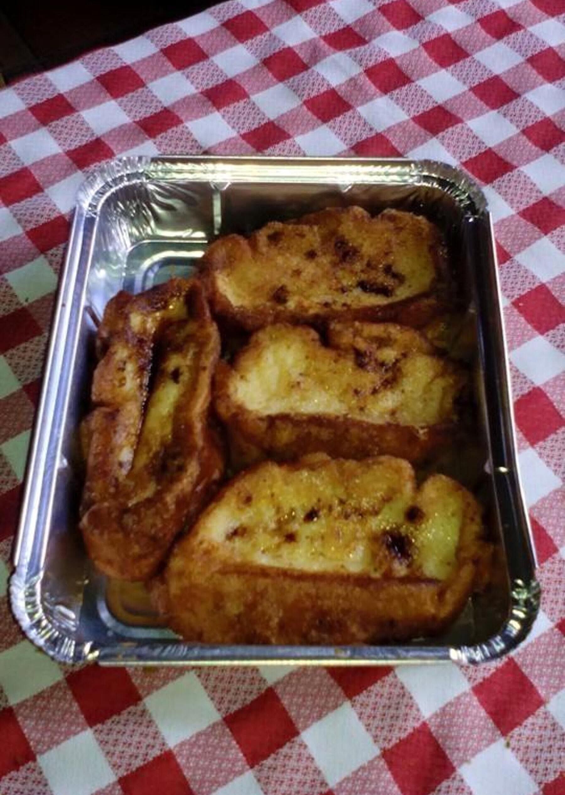 Una bandeja de tostadas francesas sobre un mantel a cuadros.