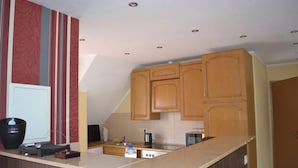 A kitchen with wooden cabinets, a countertop, and a sink. - Ferienwohnung Resit 2 (Wunstorf)