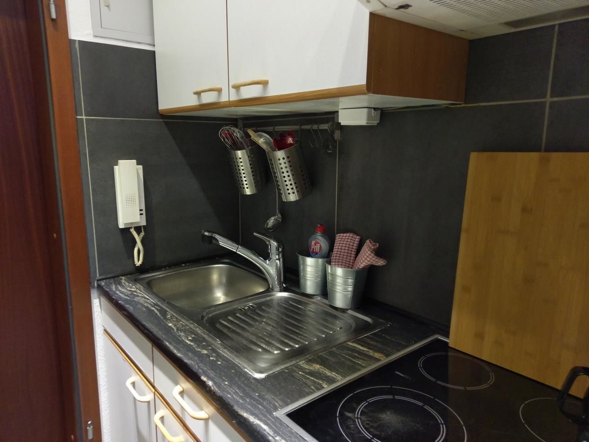 Una cocina compacta con un lavamanos doble, estufa y una pequeña zona de encimera.