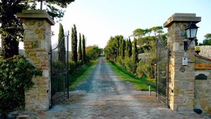 A paved pathway leading to a stone gate with a sign reading "San Giorgio." - San Giorgio Country Residence (Santa Luce)