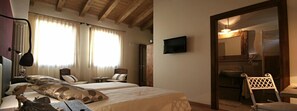 A hotel room with two beds, a TV, a mirror, and a chair. - Bed & Breakfast Ai Cracchi (Cornedo Vicentino)