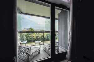 A balcony with a view of a bridge and greenery.