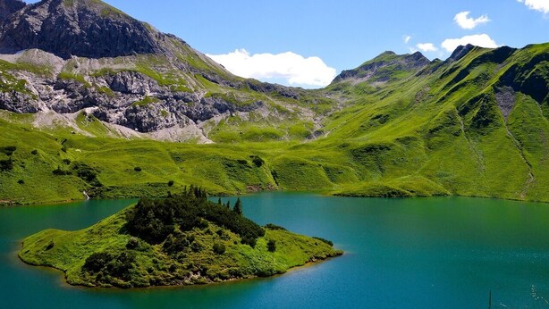 A mountainous landscape with a lake and a small island. - Berggasthof Sonne Imberg (Sonthofen)