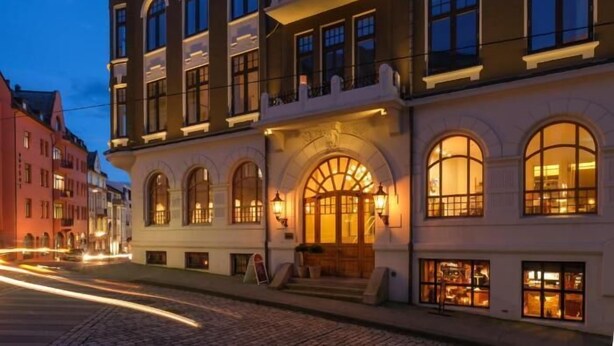 Un edificio histórico con ventanas arqueadas y una torre destacada.