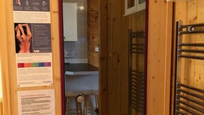 A wooden interior with a bathroom and a kitchen area. - Astoria (Broadstairs)