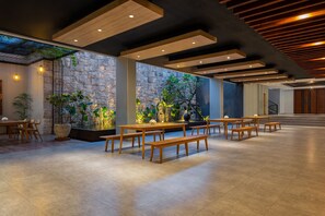 A spacious indoor area with wooden tables and benches, stone walls, and a modern ceiling design. - favehotel Sidoarjo (Sidoarjo)