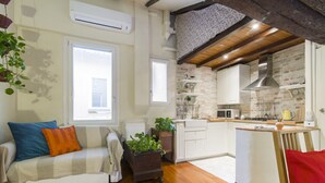 Een moderne keuken met een tegelachtergrond, houten balken en een klein eiland.