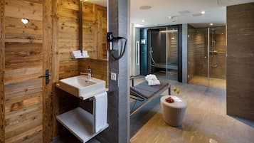 Une salle de bain moderne avec un mur en bois, un lavabo, un porte-serviettes et une cabine de douche en verre.
