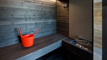Un baño moderno con paneles de madera, un banco y un perchero de metal.