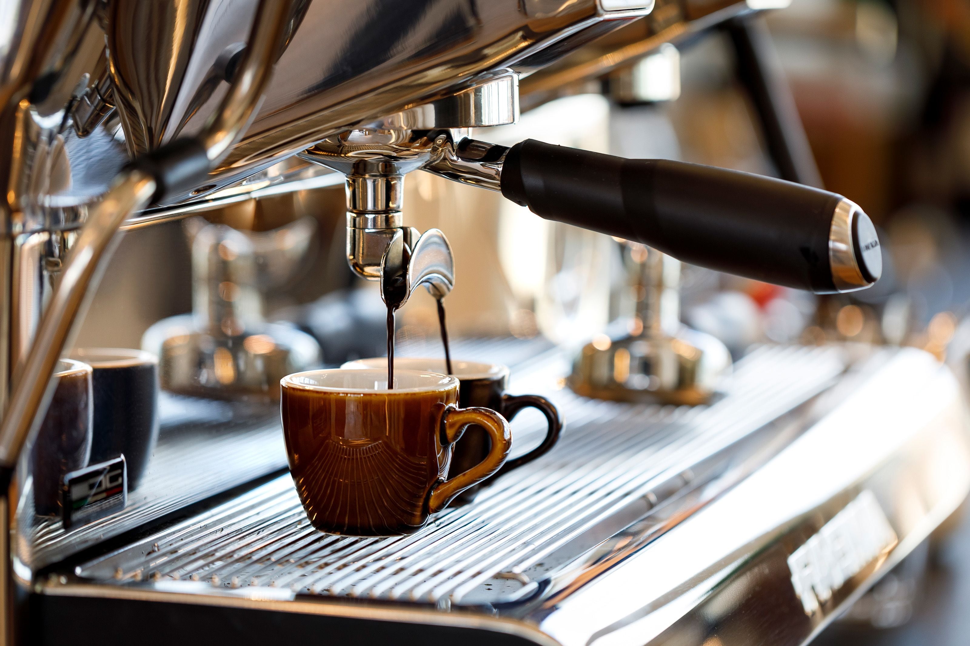 A close-up of a coffee machine with a cup of coffee being dispensed.