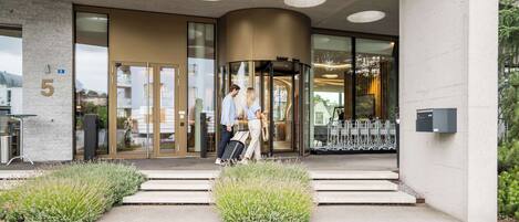 A modern building entrance with a revolving door, glass doors, and a number '5' sign.
