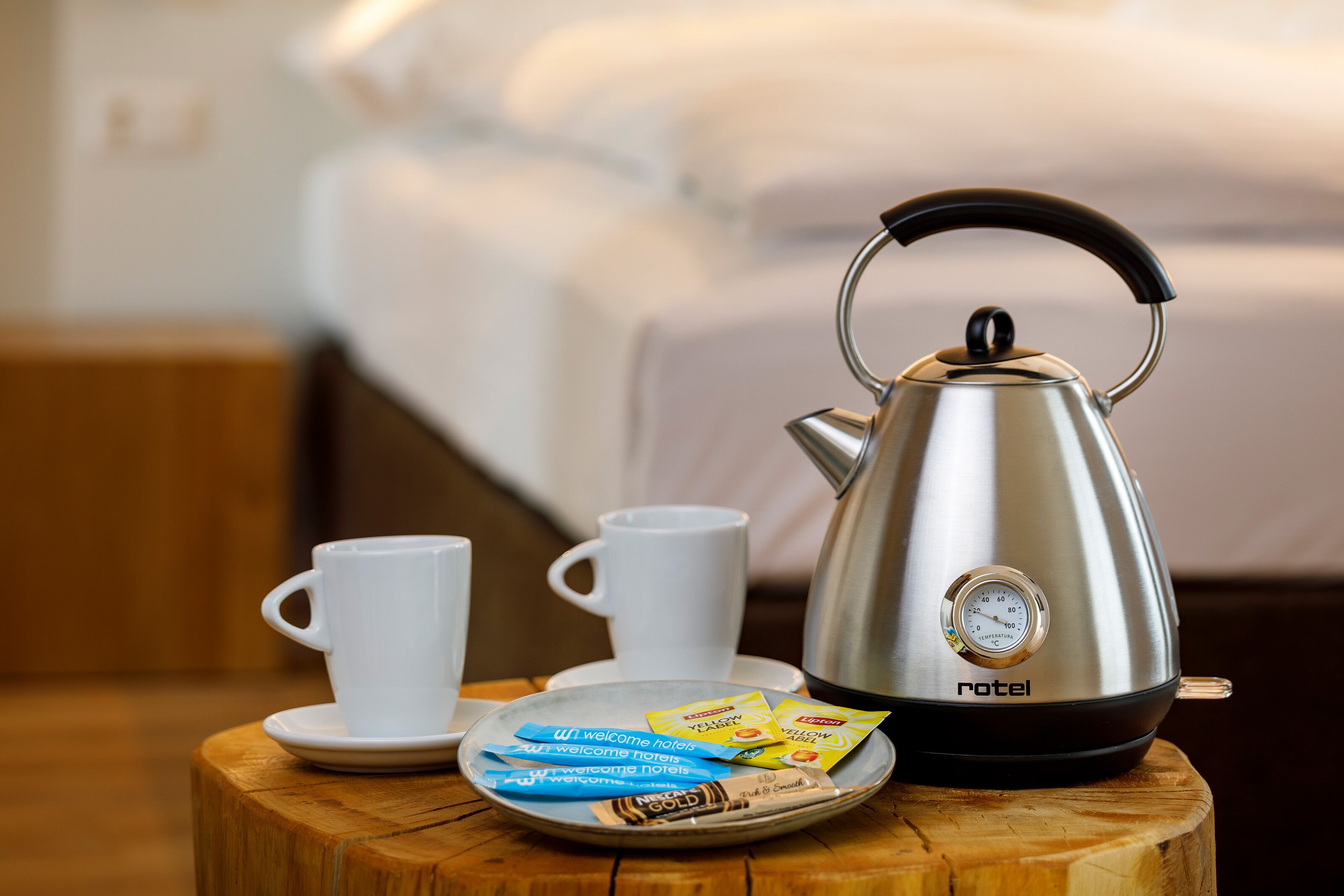 Una kitchenette con hervidor, dos tazas y un plato de bolsitas de té.