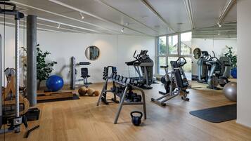 A gym with various exercise equipment, including treadmills, dumbbells, and exercise balls.