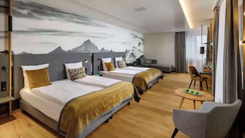 Una habitación de hotel con dos camas, un sofá, una mesa de comedor con manzanas y una silla.