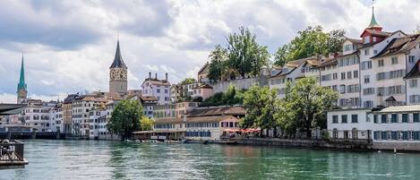 Un río con edificios a lo largo de sus orillas, incluyendo una torre y una iglesia.