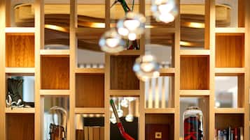A wooden bookshelf with various items including books, a glass dome, and hanging objects.