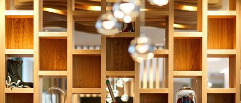 A wooden bookshelf with various items including books, a glass dome, and hanging objects.