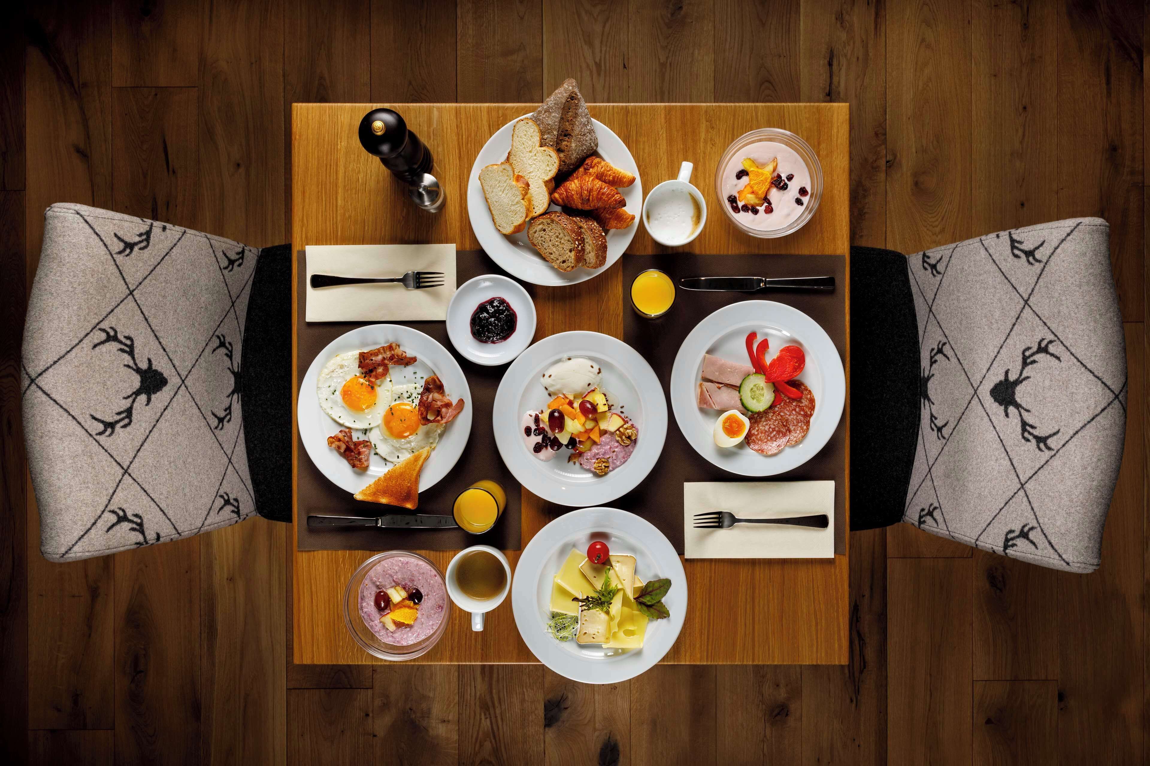 A breakfast table with various dishes, including eggs, toast, and fruit.