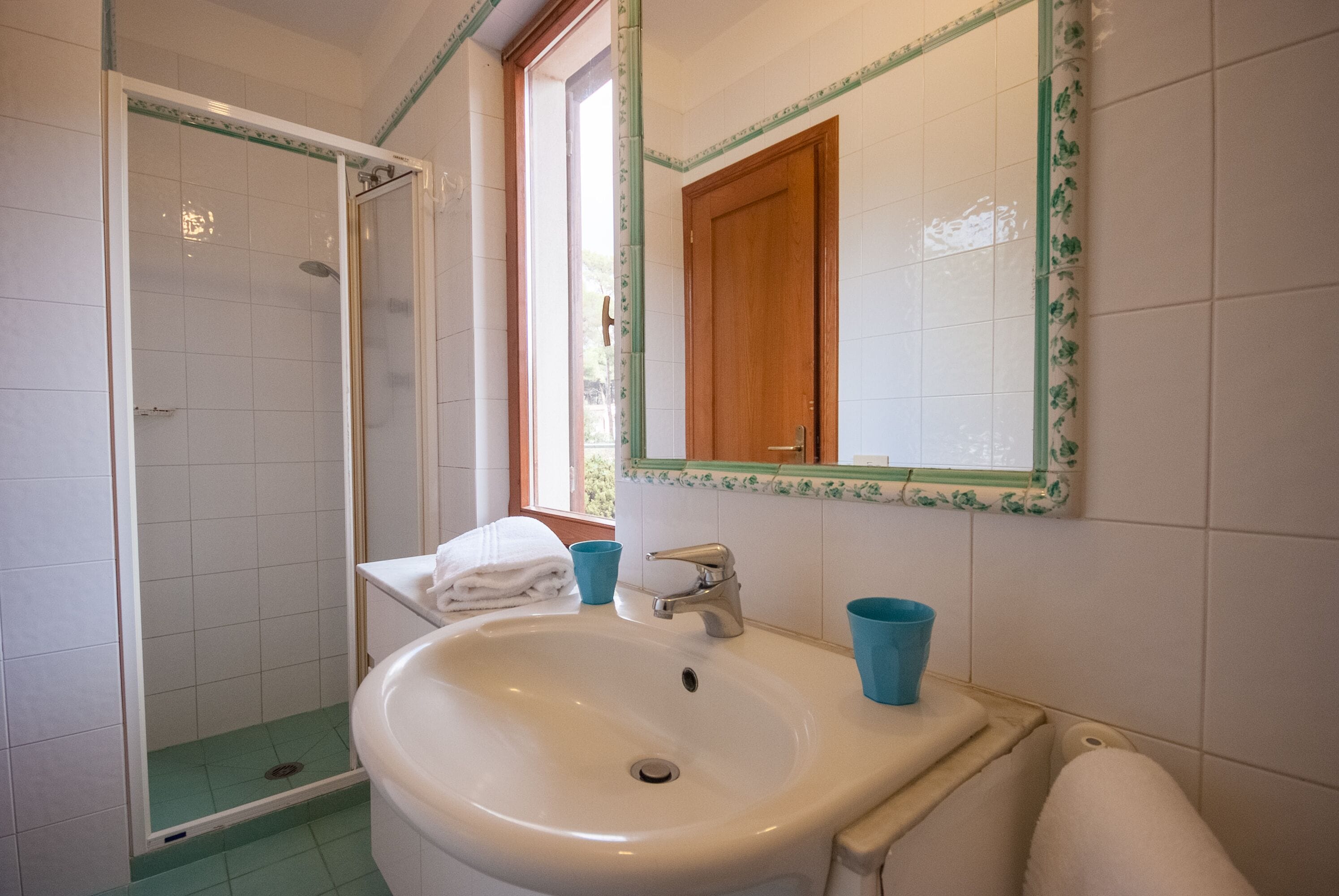 A bathroom with a shower, sink, and mirror.