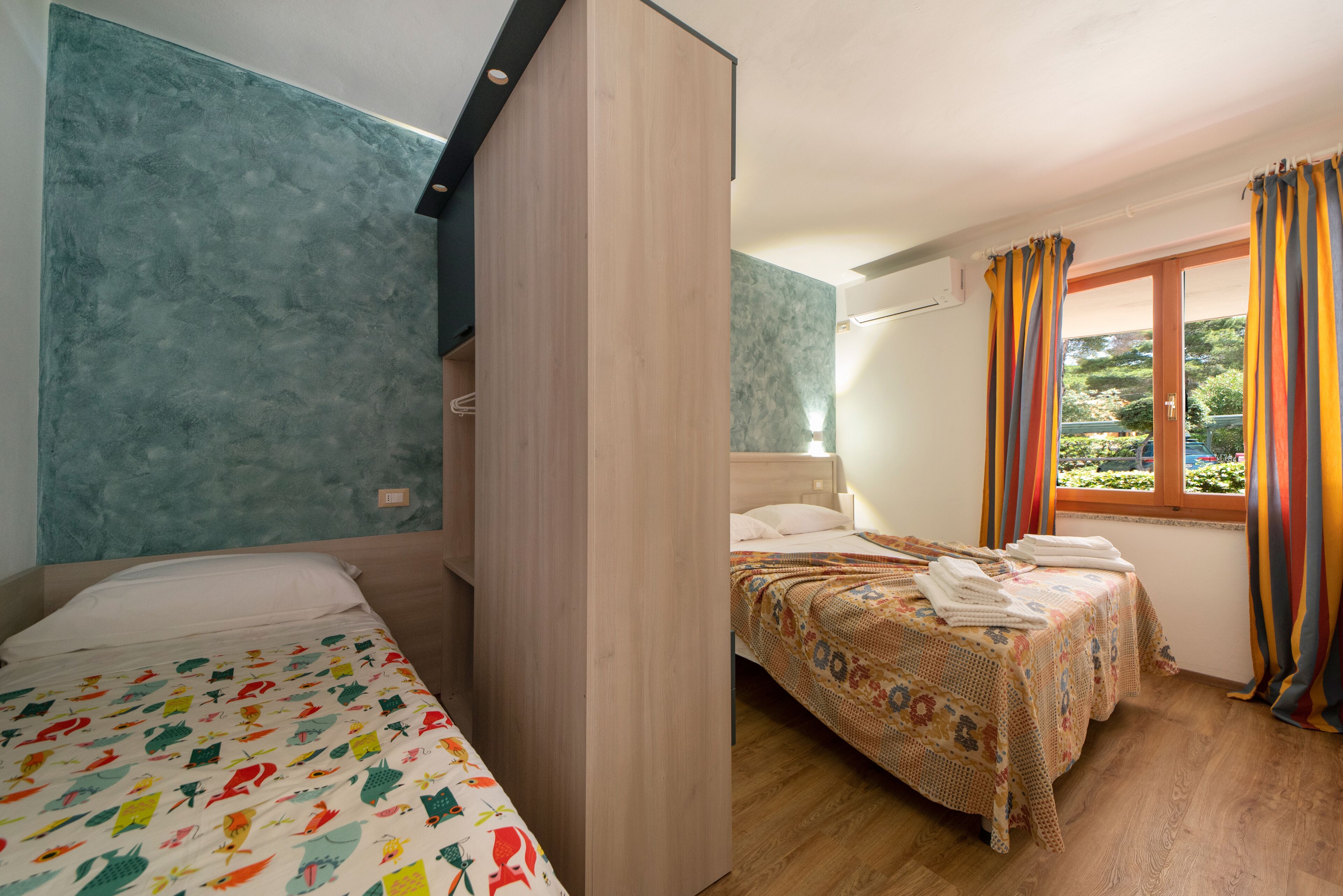 Ein Schlafzimmer mit einem Bett, einem Kleiderschrank und einem Fenster mit Vorhängen.