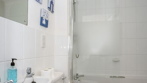 Un bagno con lavandino, WC e cabina doccia in vetro.
